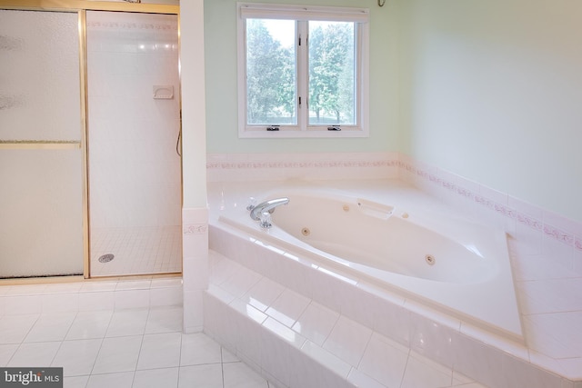 bathroom with a jetted tub, a shower stall, and tile patterned flooring