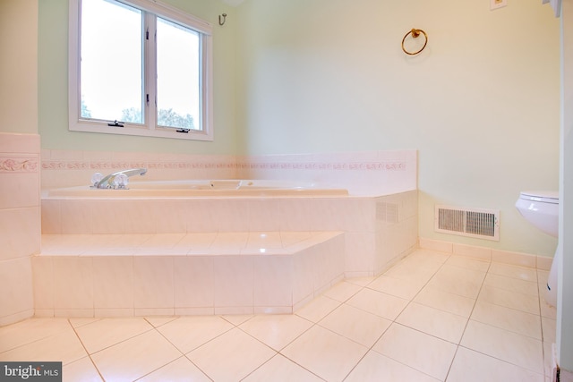 full bath featuring tile patterned flooring, a garden tub, and visible vents