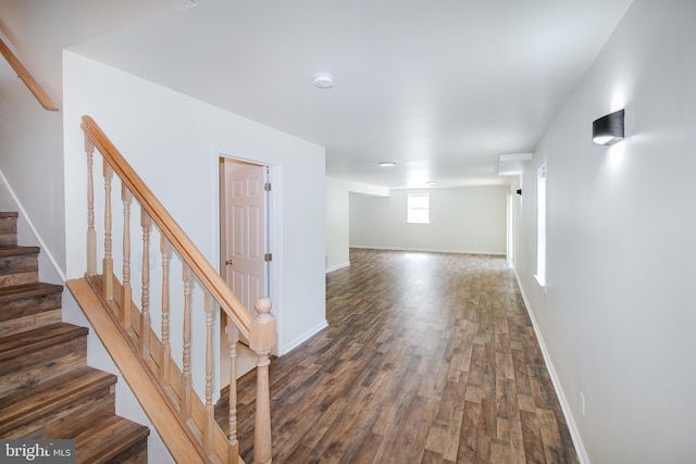 interior space featuring stairs, baseboards, and dark wood-style flooring