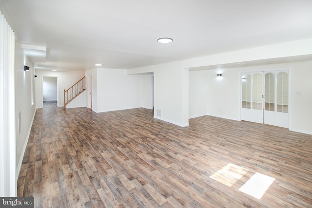 interior space featuring stairway, baseboards, visible vents, and wood finished floors