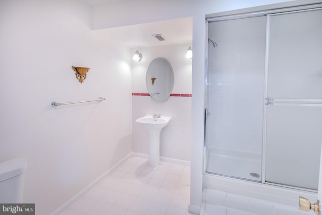 full bathroom featuring a shower stall, toilet, tile walls, and visible vents