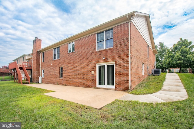 rear view of house with a yard, a patio, central AC unit, and stairs