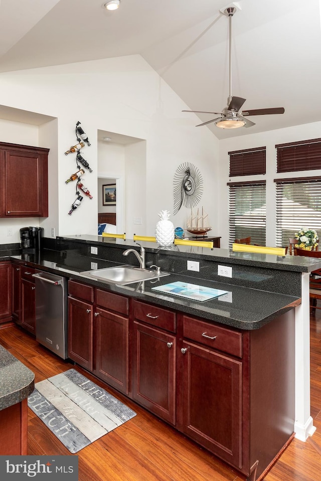 kitchen featuring vaulted ceiling, dishwasher, sink, ceiling fan, and light wood-type flooring