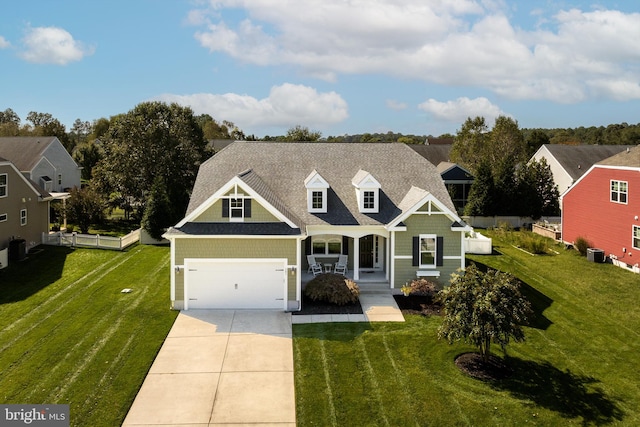 view of front of house with a front lawn, a garage, covered porch, and central AC