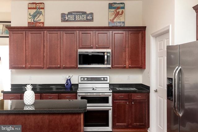 kitchen featuring appliances with stainless steel finishes and dark stone countertops