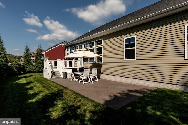 back of property with a lawn and a patio area