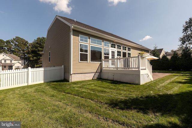 back of property with a wooden deck and a yard