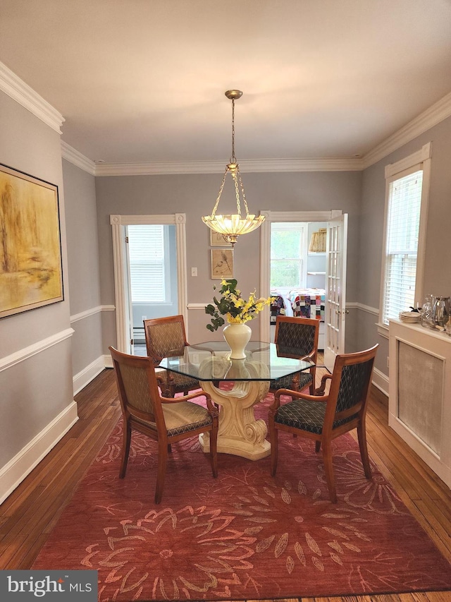 dining room featuring crown molding, a healthy amount of sunlight, and dark hardwood / wood-style flooring