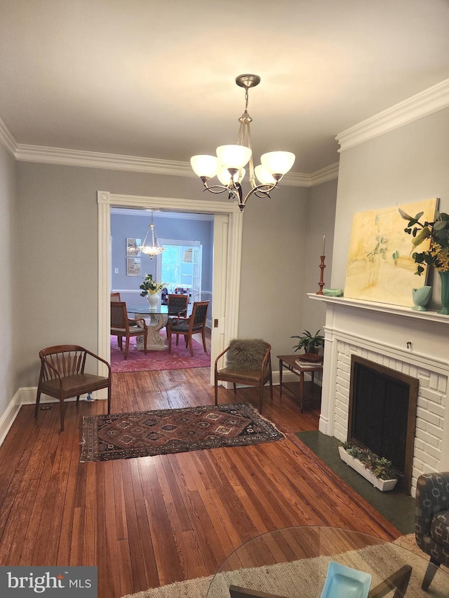 living room with an inviting chandelier, ornamental molding, a fireplace, and dark hardwood / wood-style flooring