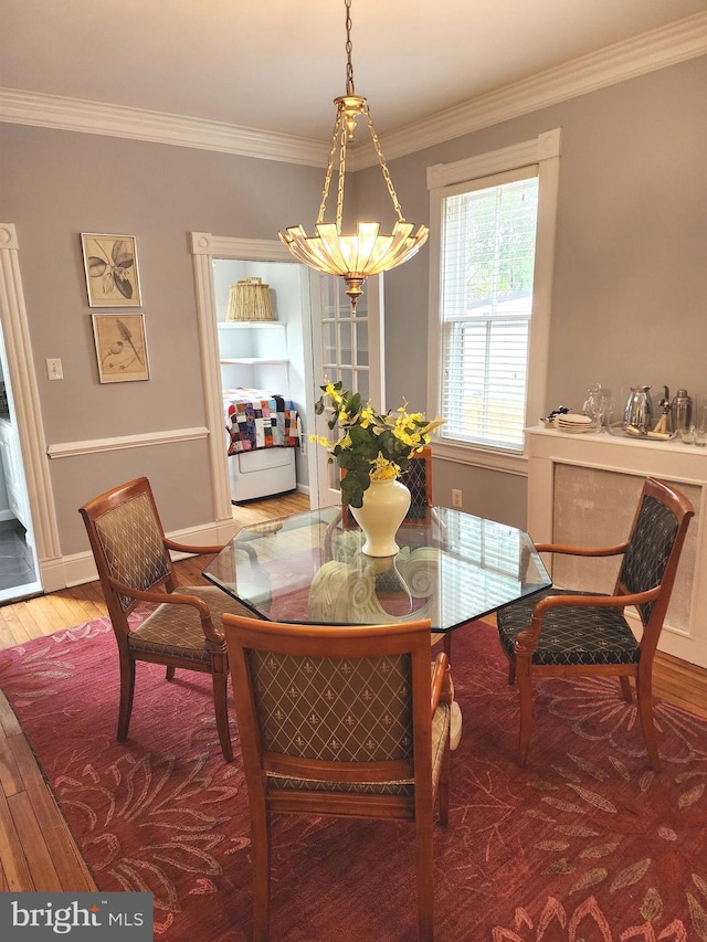 dining room with ornamental molding, a chandelier, and hardwood / wood-style floors