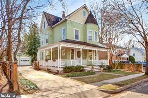 view of front of home featuring an outdoor structure, a garage, and covered porch