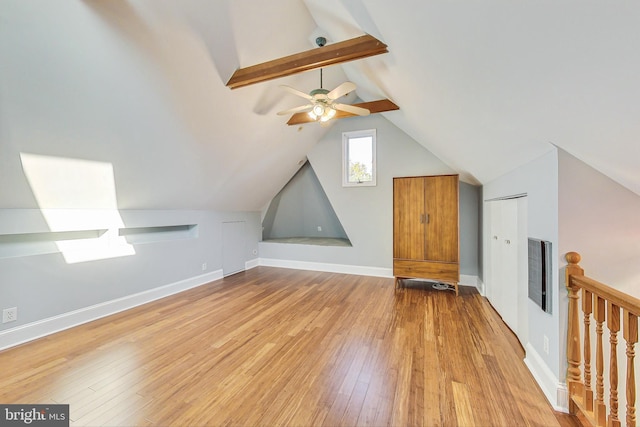 additional living space with light hardwood / wood-style flooring, vaulted ceiling with beams, and ceiling fan