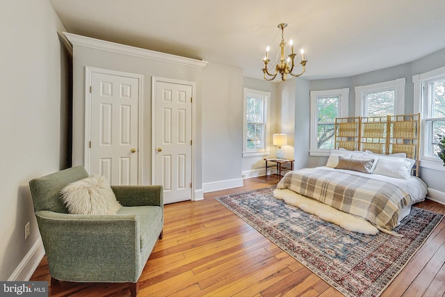 bedroom featuring an inviting chandelier and light hardwood / wood-style floors