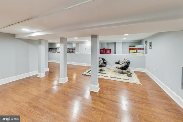 workout area with light hardwood / wood-style floors and ornate columns