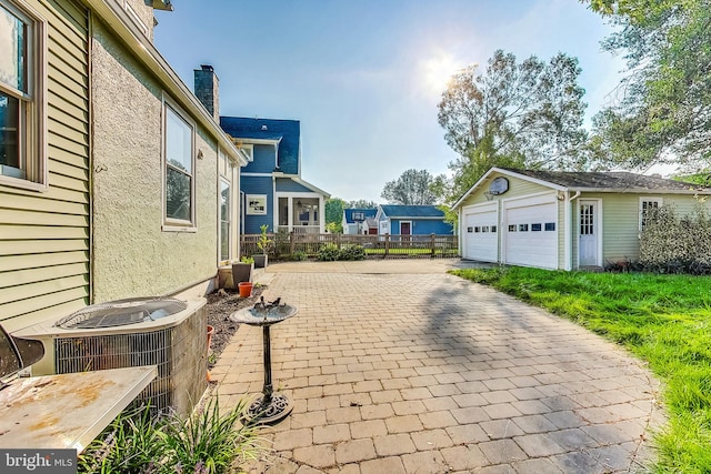 view of patio / terrace featuring an outdoor structure, a garage, and central air condition unit