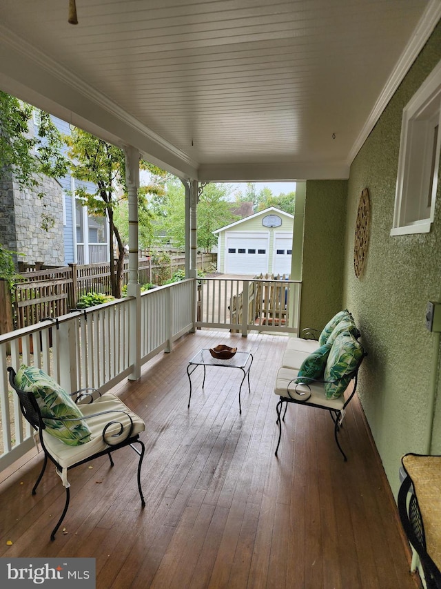 deck featuring a garage, a porch, and an outbuilding