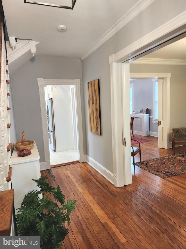 hallway with ornamental molding and hardwood / wood-style floors