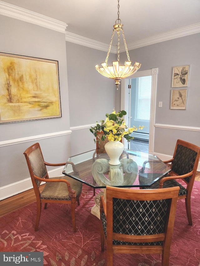 dining space featuring ornamental molding, a baseboard heating unit, and hardwood / wood-style flooring