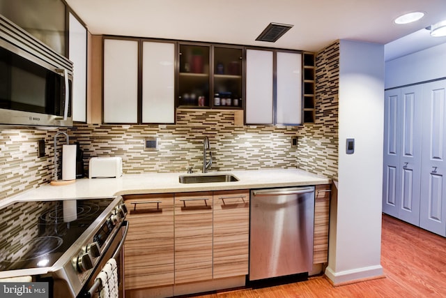 kitchen featuring appliances with stainless steel finishes, light countertops, visible vents, and a sink