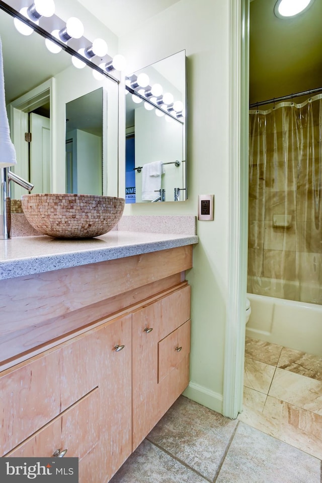 bathroom with toilet, shower / bathtub combination with curtain, vanity, and tile patterned floors