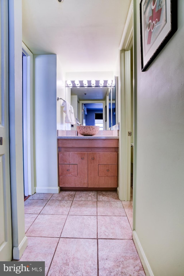 bathroom with tile patterned flooring, vanity, and baseboards