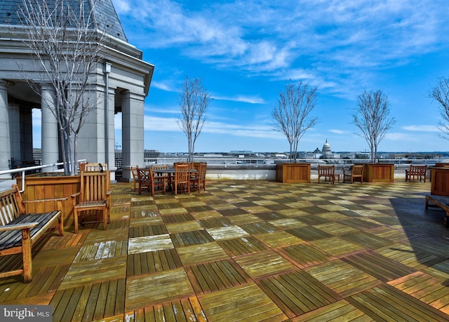 wooden terrace featuring outdoor dining space and a water view