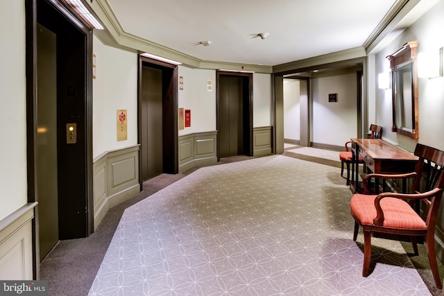 bedroom with elevator, ornamental molding, a decorative wall, and a wainscoted wall