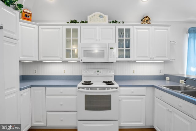 kitchen with sink, white appliances, and white cabinets