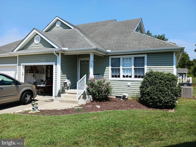 view of front of house with a garage, covered porch, central AC, and a front yard