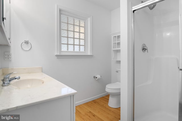 bathroom featuring vanity, toilet, hardwood / wood-style floors, and walk in shower