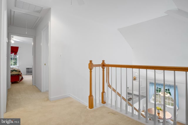 corridor featuring vaulted ceiling and light carpet