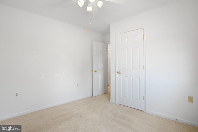 unfurnished bedroom featuring ceiling fan and light colored carpet