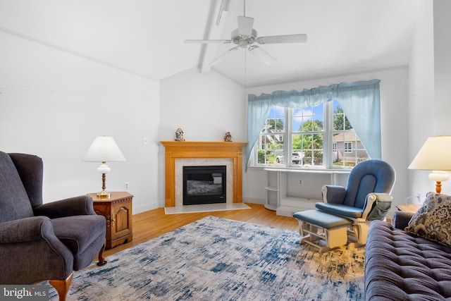 living room featuring light wood-type flooring, ceiling fan, and vaulted ceiling with beams