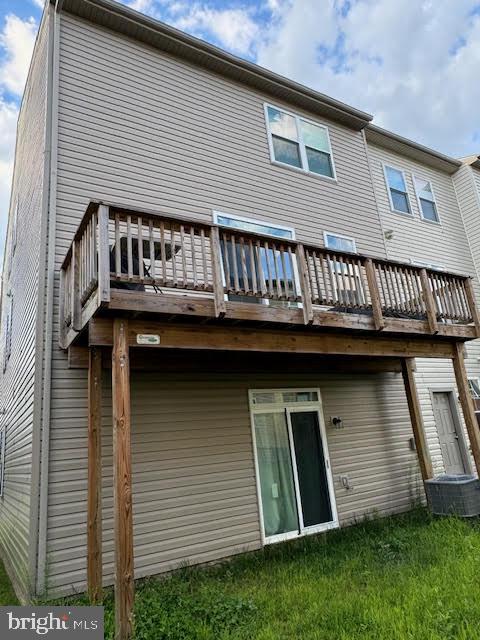 rear view of house featuring a wooden deck and central air condition unit