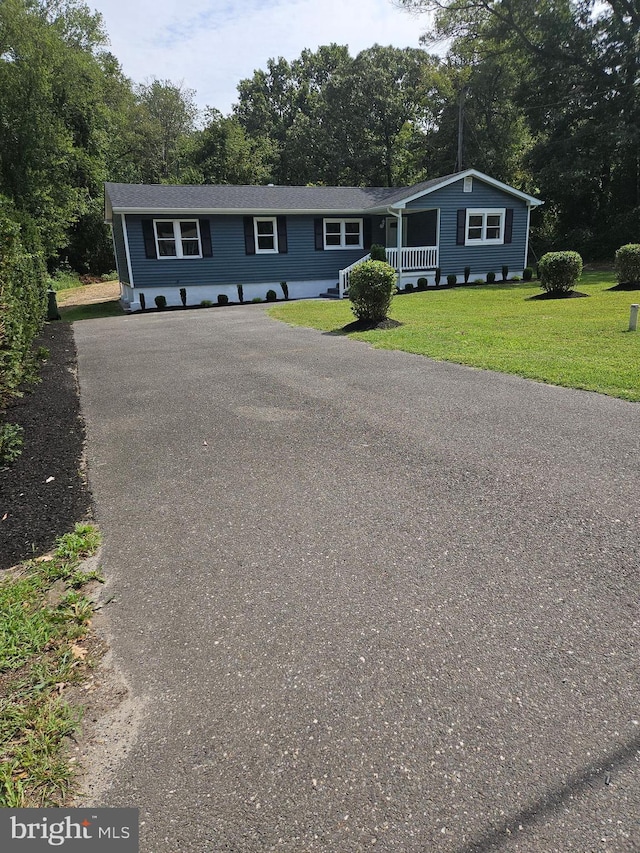 view of front of property with driveway, a porch, and a front yard