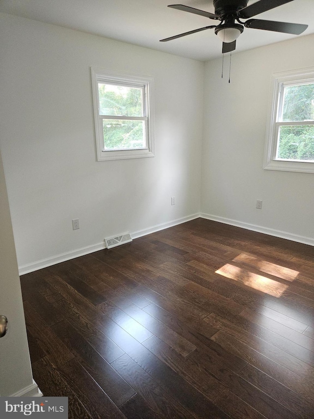 unfurnished room with a ceiling fan, baseboards, visible vents, and wood finished floors