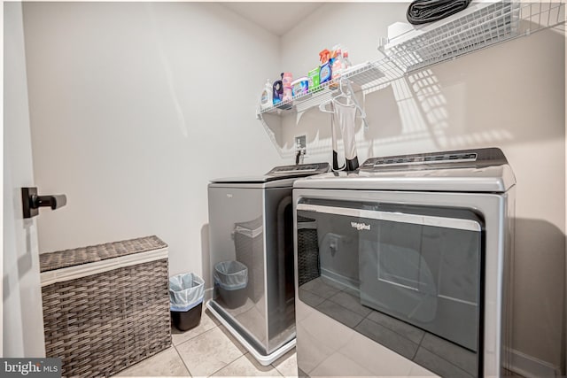 clothes washing area with light tile patterned floors and washing machine and dryer