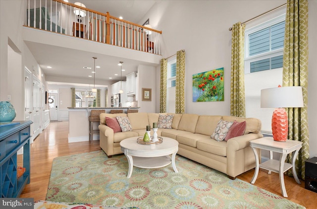 living room featuring a high ceiling and light hardwood / wood-style floors