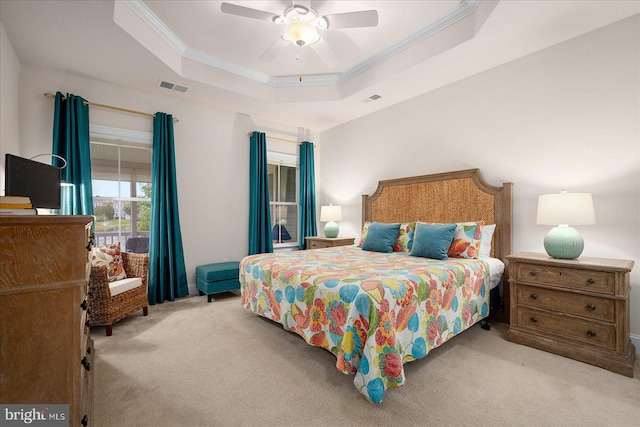 carpeted bedroom featuring crown molding, ceiling fan, and a tray ceiling