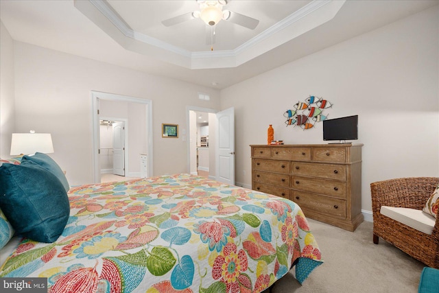 carpeted bedroom with a raised ceiling, ceiling fan, ornamental molding, and connected bathroom