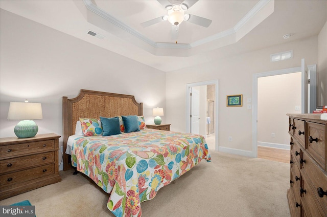 bedroom with a tray ceiling, light colored carpet, and ceiling fan