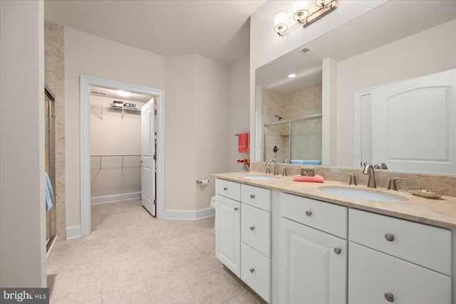 bathroom featuring a shower with shower door and vanity