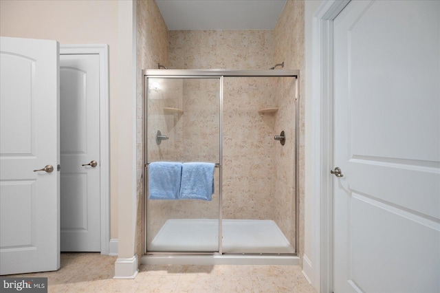 bathroom with a shower stall and tile patterned floors