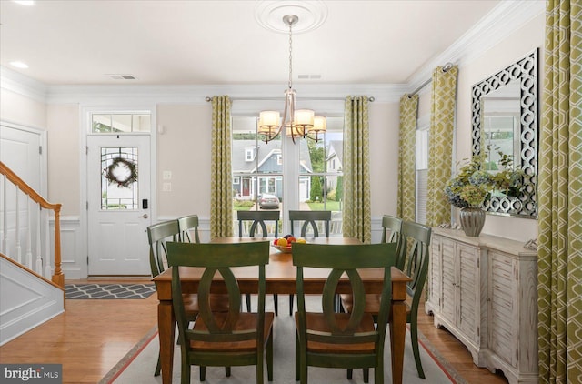 dining area featuring visible vents, stairway, crown molding, and wood finished floors