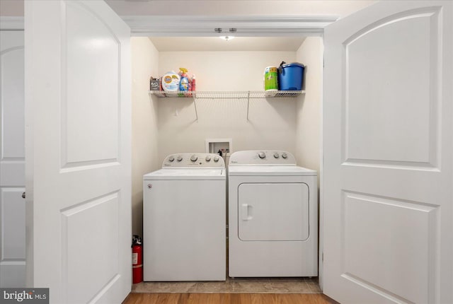 laundry room featuring light hardwood / wood-style flooring and separate washer and dryer