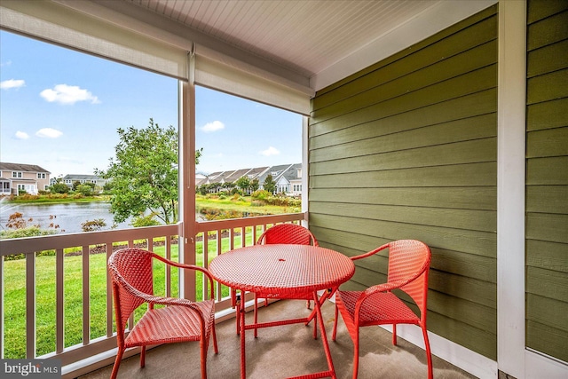 exterior space featuring a residential view, a sunroom, and a water view