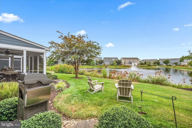 view of yard featuring a water view and a sunroom