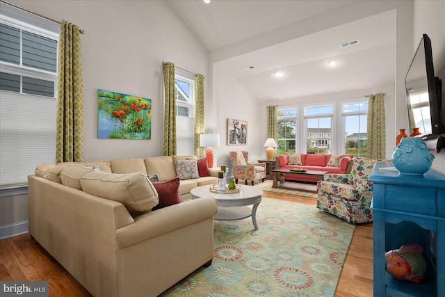 living room featuring high vaulted ceiling and wood-type flooring