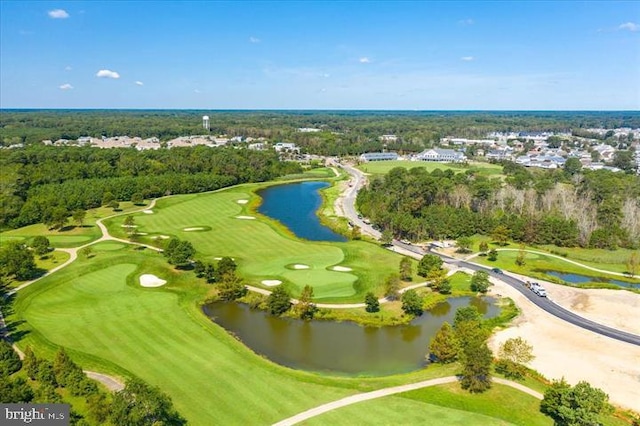 aerial view with view of golf course, a forest view, and a water view