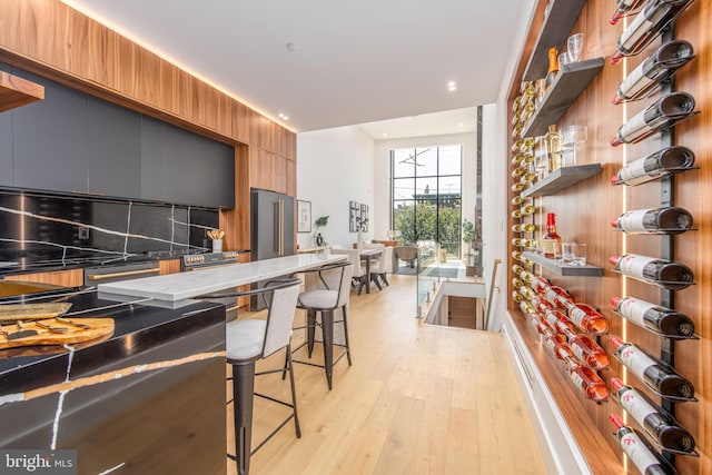 kitchen with a kitchen breakfast bar and light hardwood / wood-style floors